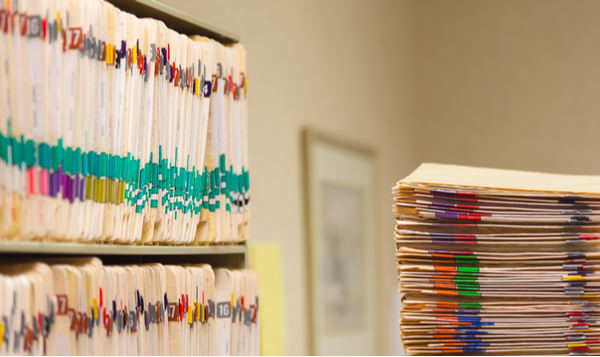 Medical records sit on a shelf and a desk.